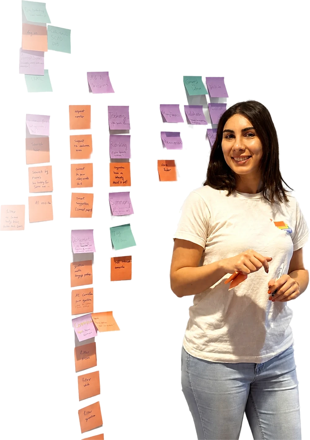 Maryam beside a wall of sticky notes from an affinity mapping session.