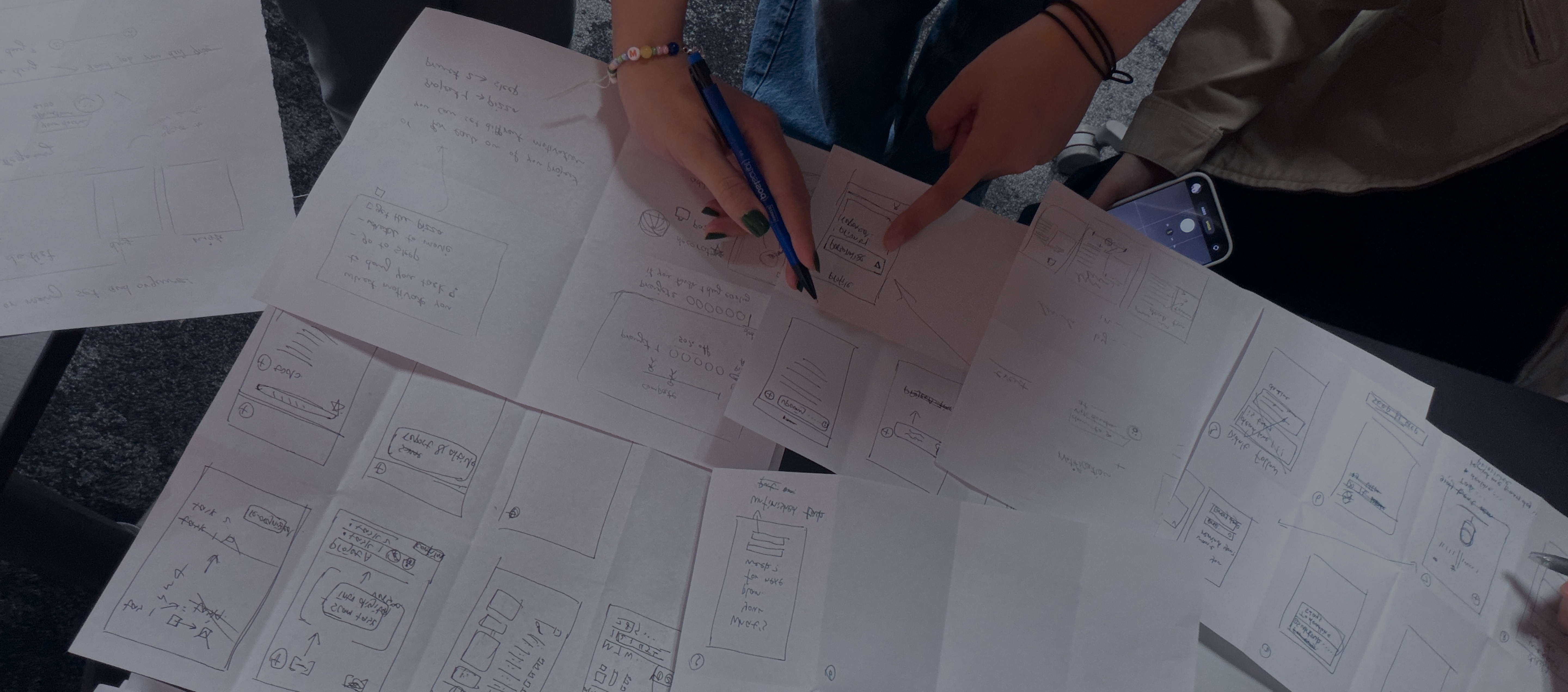 Hands sketching wireframe ideas on paper